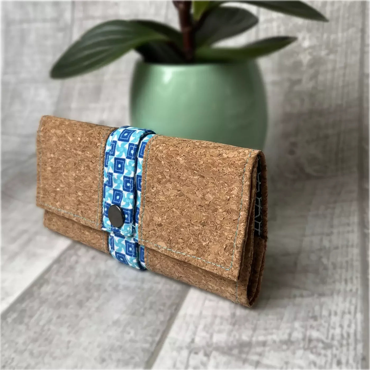 Blague à tabac artisanale CATASTROFF en liège avec fermeture bleue à motifs géométriques.