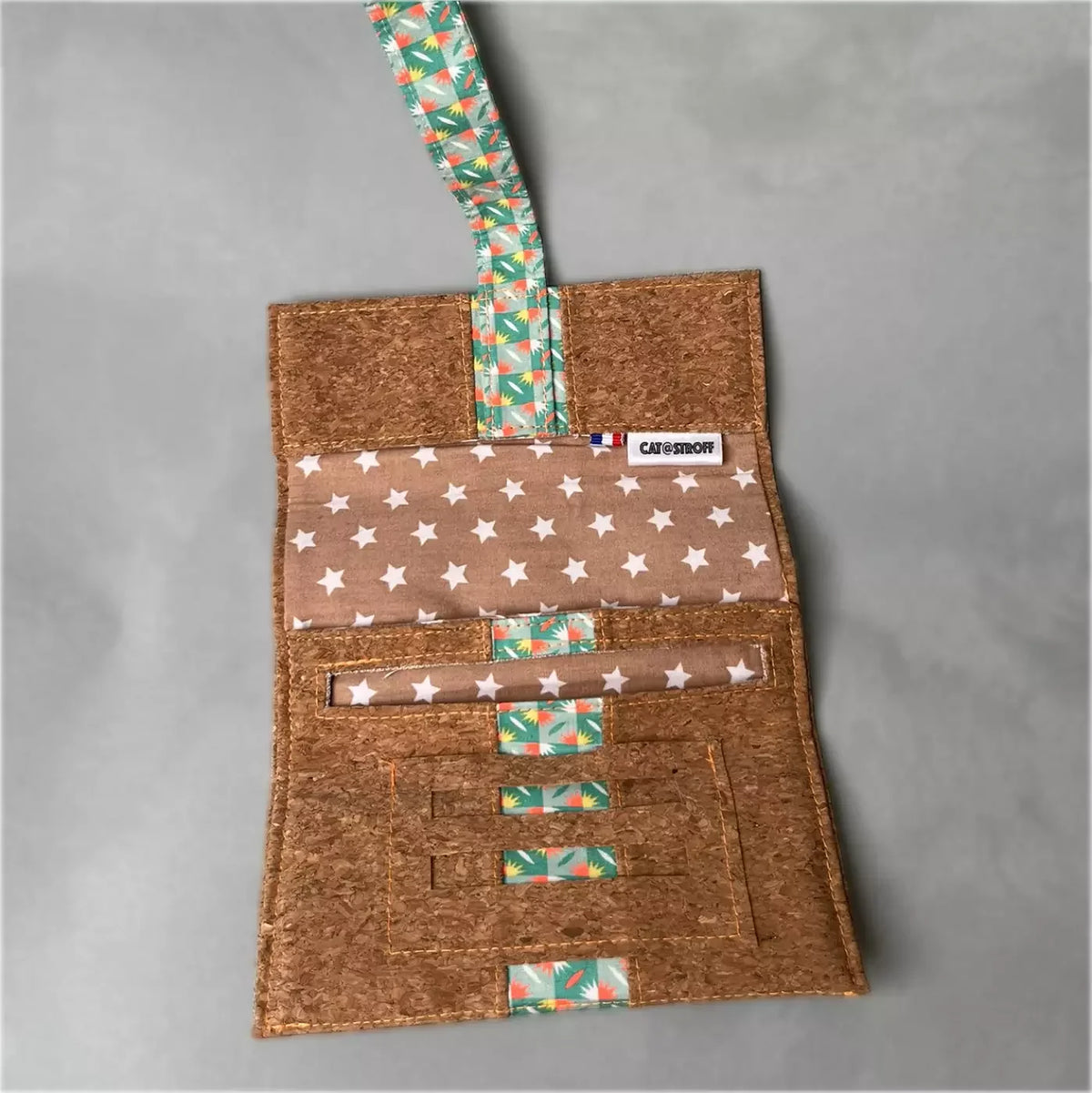 Blague à tabac artisanale en liège avec motifs géométriques fluo et étoiles.