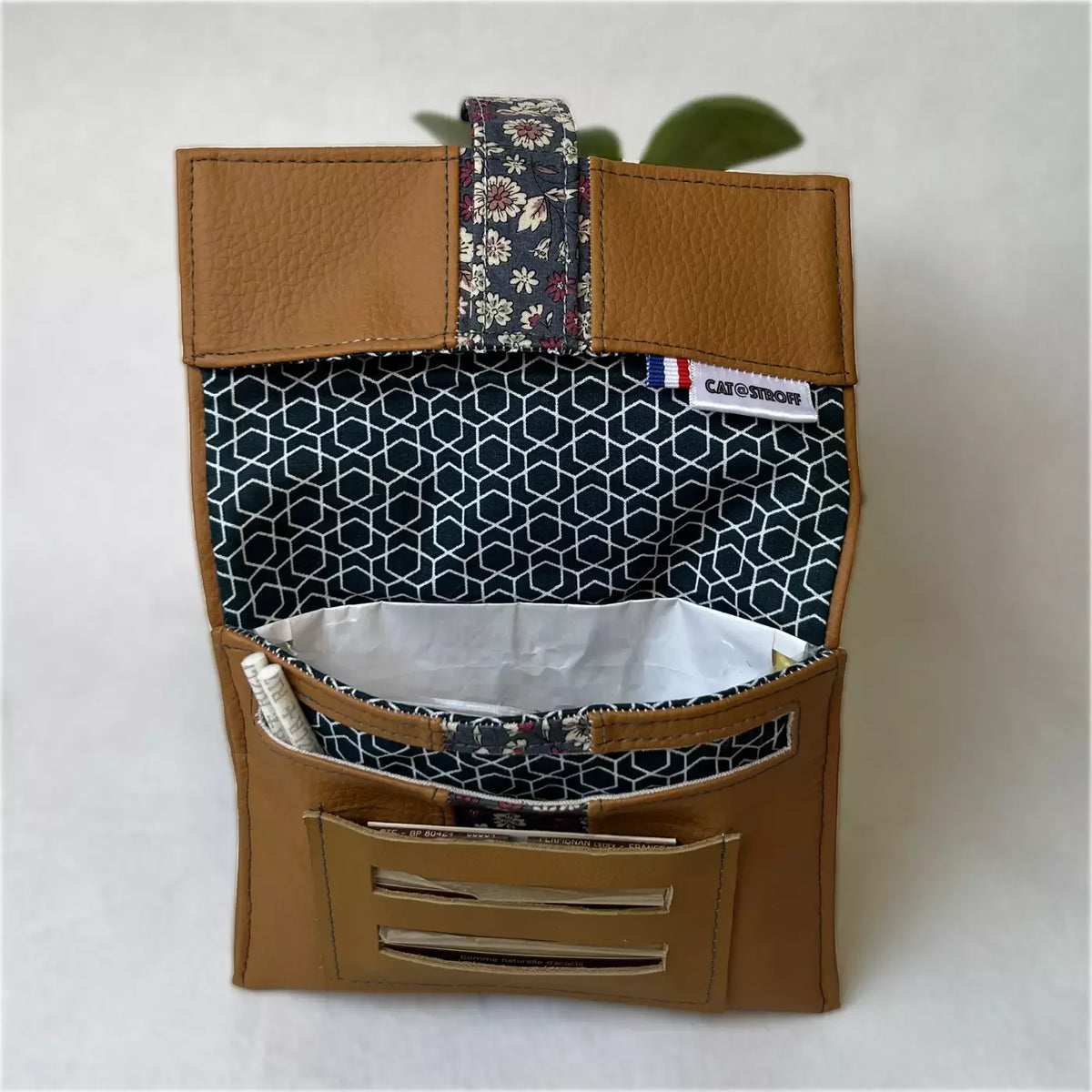 Blague à tabac Camel Fleuri en cuir marron avec doublure géométrique bleue.