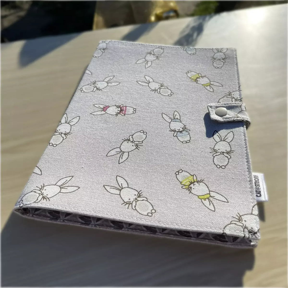Cahier de coloriage lavable CATASTROFF avec motifs de lapins sur tissu gris.