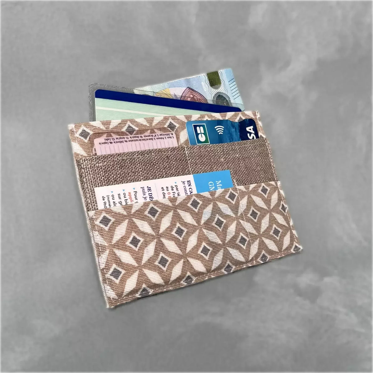 Porte-cartes slim CATASTROFF avec motif mosaïque beige et blanc contenant des cartes et billets.