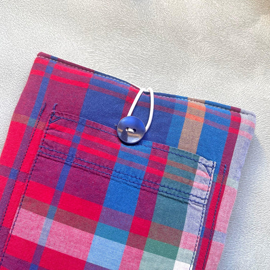 Zoom sur le bouton de récupération bleu marine de la pochette à livre en tissus madras