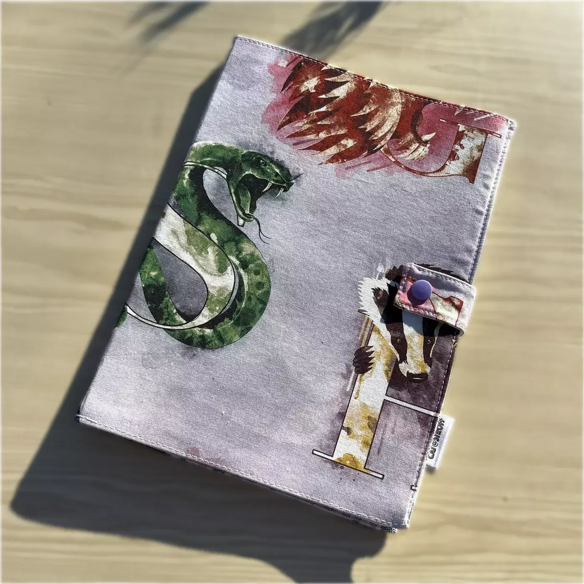 Cahier de coloriage lavable Purple Potter par CATASTROFF avec motif serpent vert.