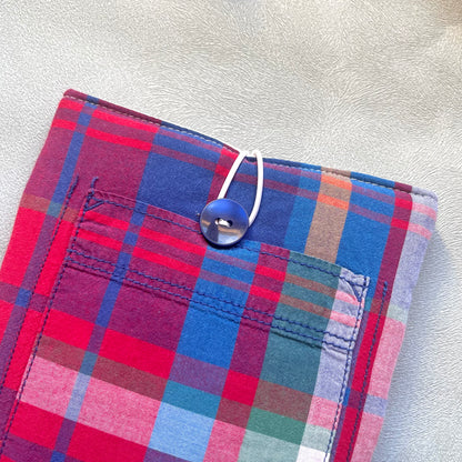 Zoom sur le bouton de récupération bleu marine de la pochette à livre en tissus madras