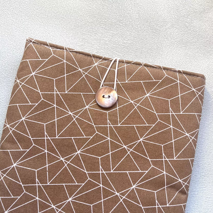 Zoom sur le bouton de récupération nacré de la pochette à livre en coton marron motif géométrique
