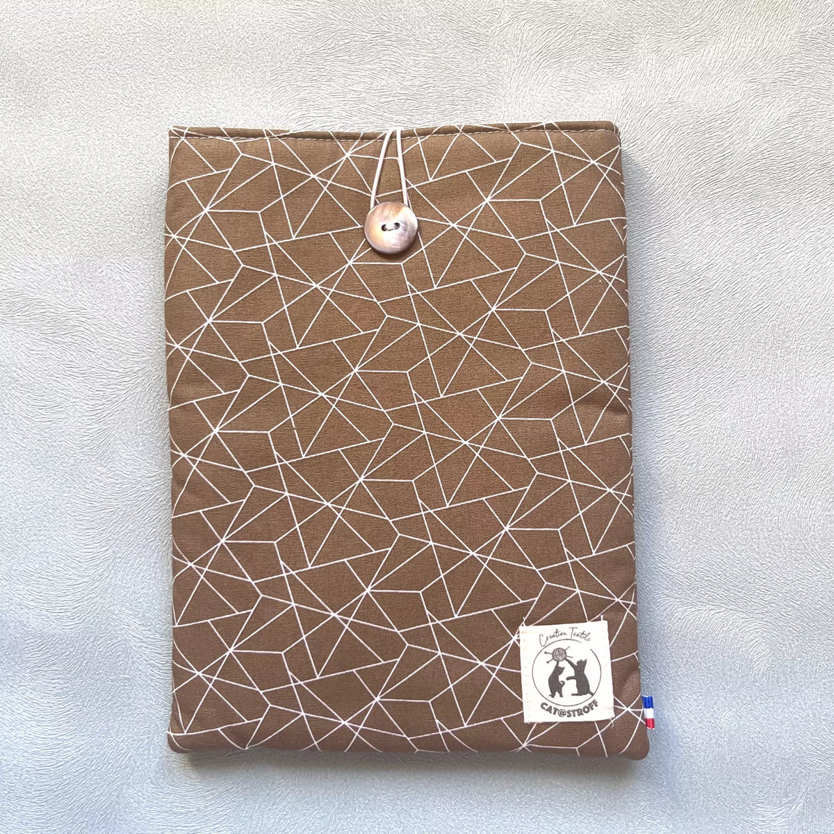 Pochette à livre en coton marron motif géométrique blanc, fermée par un bouton nacré de récupération, cousue main par Catastroff