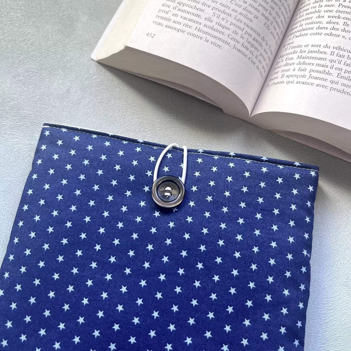 Gros plan sur la fermeture élastique et bouton de récupération de la housse livre poche tissu fait main La Belle Étoile, motif étoilé bleu nuit bien net.