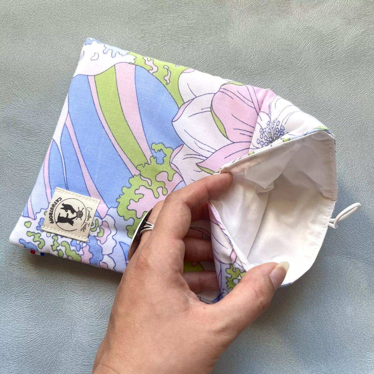Pochette à livre en coton fleuri pastel upcyclé, intérieur en coton blanc écru visible sur la photo, cousue main par l'atelier Catastroff