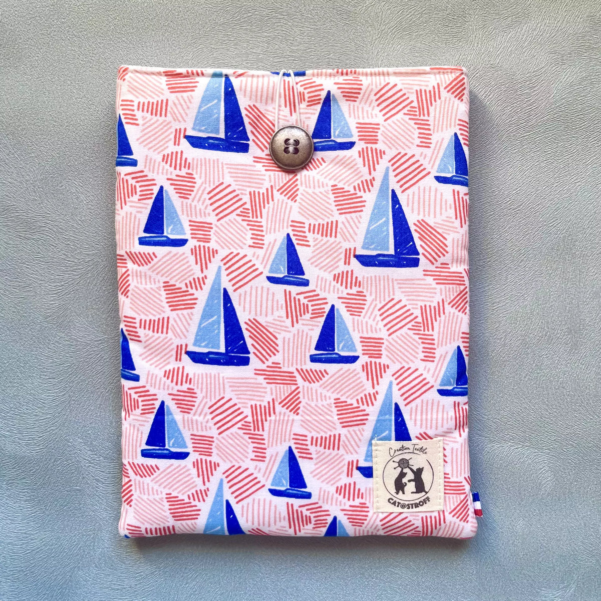 Pochette à livre tissu coton imprimé voiliers bleus et traits roses, cousue main, fermée par un bouton récupéré