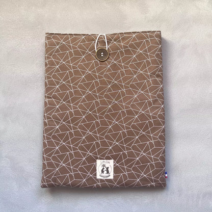 Pochette livre broché marron vue de face fermée, motif triangles géométriques blancs, bouton de récupération ton bois et étiquette Catastroff