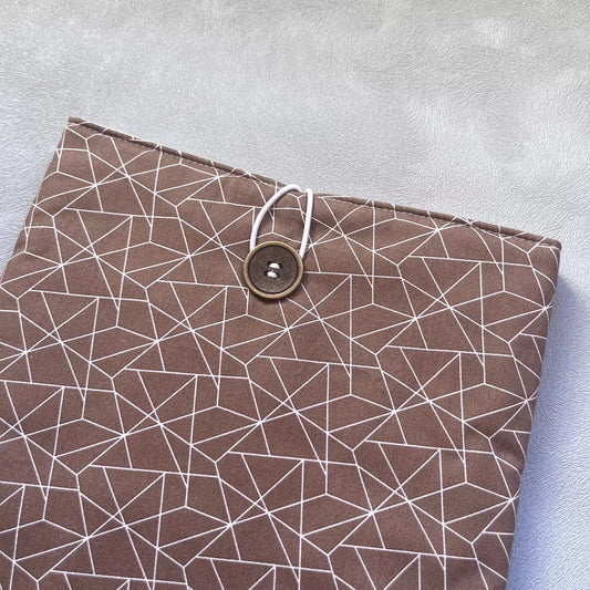 Gros plan sur la fermeture élastique et bouton chiné de la pochette livre tissu fait main, détail du coton cacao et des coutures soignées