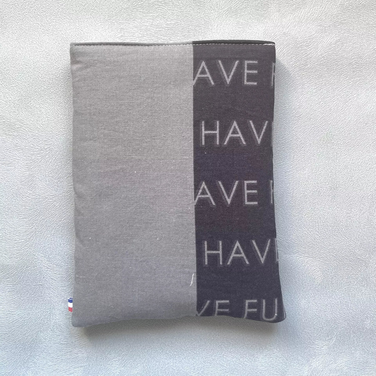 Dos de la pochette à livre en tissu upcyclés, avec une partie du tissu noir avec les inscription have fun et le reste du tissu en gris